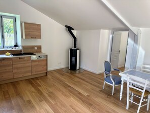 A modern kitchen with wooden cabinets, a built-in dishwasher, and a black stove. - 2 country houses, sleeps 8, swimming pool (Saint-Denis-d'Anjou)