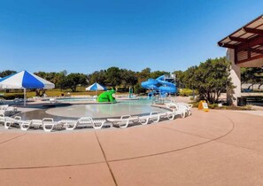 A water park with a pool, slides, and lounge chairs.
