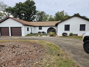 A two-story house with a garage, a driveway, and a lawn.