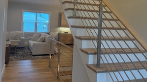 Una escalera de madera con barandillas de metal que conduce a un nivel superior.