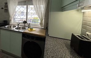 A compact kitchen with a washing machine, a sink, and a toaster. - Cozy Apartment in Vilamoura Marina with Pool & Balcony (vilamoura)
