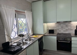 A kitchen with a built-in dishwasher, a stove, and a sink. - Cozy Apartment in Vilamoura Marina with Pool & Balcony (vilamoura)