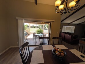 A dining area with a table, chairs, and a bowl of fruit. - Beautiful 2-bedroom townhome on golf course in Mesa (mesa)
