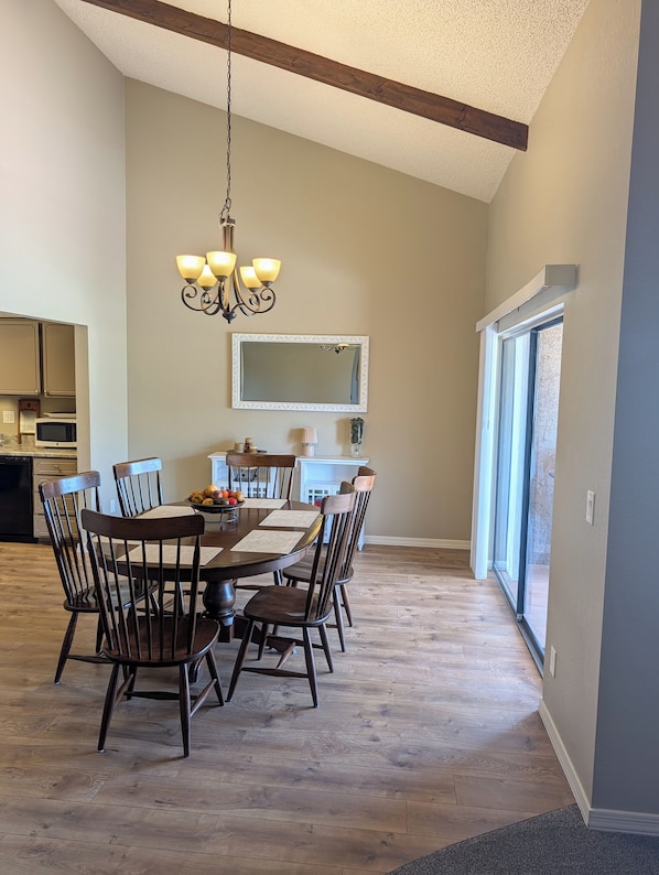 A dining area with a wooden table, chairs, and a chandelier. - Beautiful 2-bedroom townhome on golf course in Mesa (mesa)