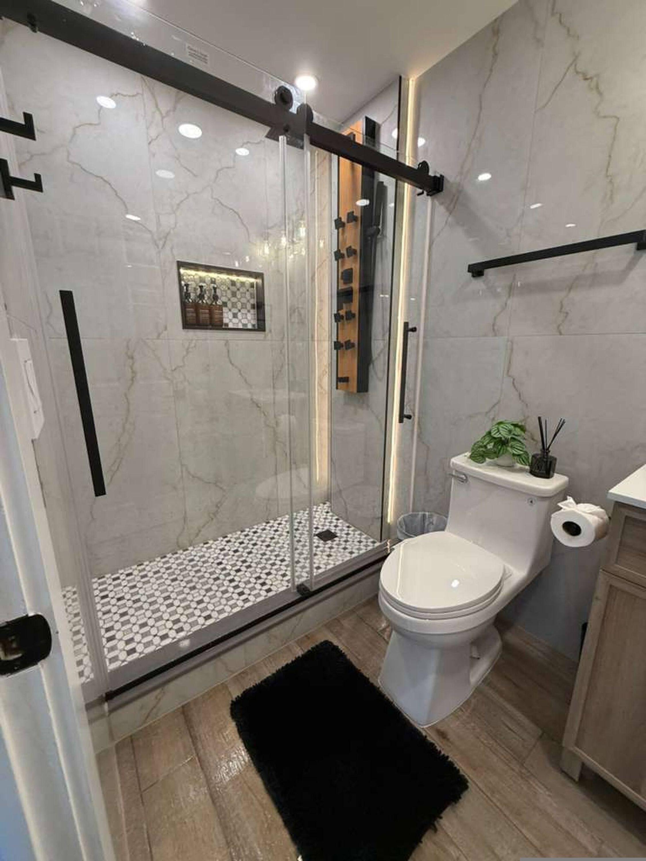 Un baño moderno con ducha de mampara, inodoro y lavabo.