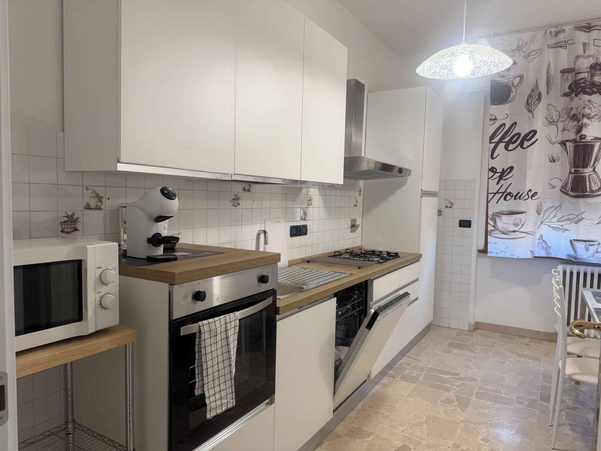 A modern kitchen with white cabinets, a microwave, an oven, a gas stove, and a dishwasher.