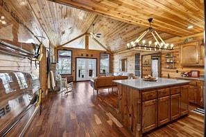 A spacious kitchen with wooden cabinets, a large island, and a dining area with a sofa.