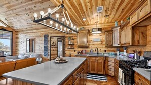 L’intérieur d’une cabane en bois comprend une cuisine, un coin repas et un salon.