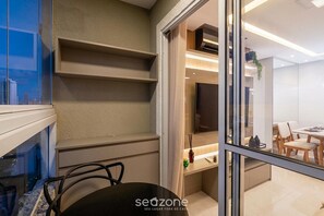 Ein modernes Interieur mit Essbereich, Fernseher und einer Glaskonstruktion.
