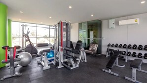 A gym with exercise equipment, benches, and a wall of dumbbells. - 2BR Comfort Pool Access Bangtao & Nightlife C178 (Chang Wat)