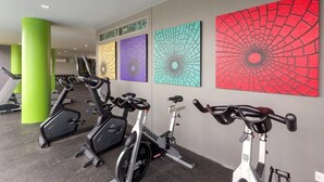 A gym with stationary bikes, green pillars, and wall art. - 2BR Comfort Pool Access Bangtao & Nightlife C178 (Chang Wat)