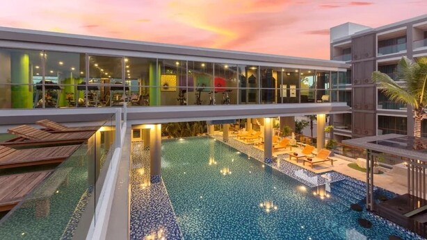 A hotel with an infinity pool, a covered area with seating, and a modern architectural design. - 2BR Comfort Pool Access Bangtao & Nightlife C178 (Chang Wat)