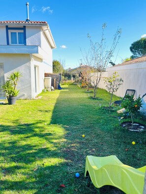 A backyard with a lawn, a yellow play tent, and a house with a tiled roof. - House city&ocean&forest (Saint-Vincent-de-Tyrosse)