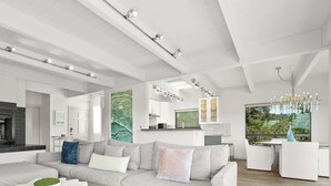 Ein modernes Wohnzimmer mit Kamin, einer Couch und einem Essbereich mit Blick.