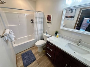 A bathroom with a bathtub, toilet, sink, and mirror. - Teton View Studio - Hidden Gem Near Yellowstone (Tetonia)