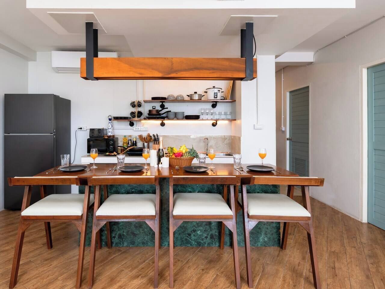 Una cocina moderna con una mesa de comedor de madera, sillas y un horno empotrado.