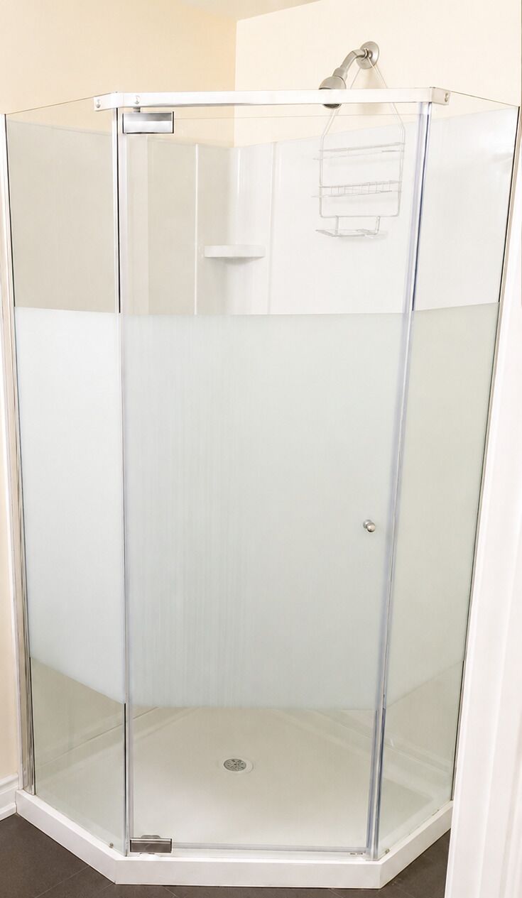Un box de ducha de vidrio transparente con base blanca y una manija de metal.