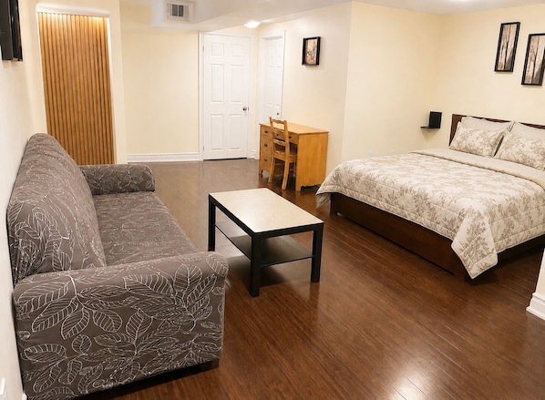 A bedroom with a bed, a sofa, a table, and a chair. - Affordable Spacious Private Suite| Ensuite Bath | Free Parking | Pearson Airport (Mississauga)