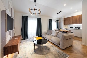 Un salon moderne avec un canapé, une table basse et un téléviseur fixé au mur.