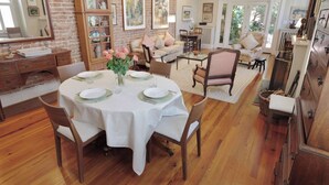 A dining area with a round table set for four, surrounded by wooden chairs. - 'Book Hill' Georgetown House, Walkable with Garage (Washington)