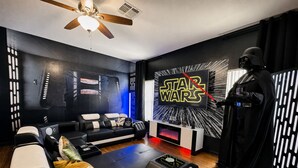 Een Star Wars-kamer met een bank, een Darth Vader-beeld en een muur met een Star Wars-logo.