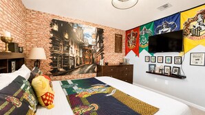 Un dormitorio con un mural de ladrillo, un televisor de pantalla plana y ropa de cama temática.