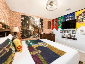 A bedroom with a brick wall mural, a flat-screen TV, and themed bedding. - Star Wars & Wizards Themed XL Pool Home Near Disney (Davenport)