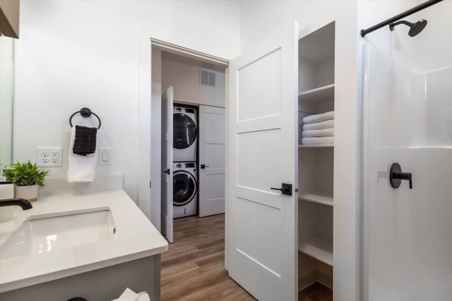 Un baño moderno con lavamanos, espejo y perchero para toallas.
