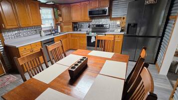 A compact kitchen with wooden cabinets, a microwave, a stove, and a refrigerator.