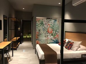Una habitación de hotel moderna con cama, escritorio y vistas al exterior.