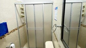A bathroom with a shower stall, a toilet, and a towel rack.