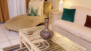 A living room with a sofa, a chair, a coffee table, and a lamp.