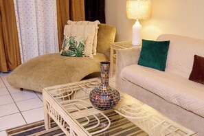 A living room with a sofa, a chair, a coffee table, and a lamp.