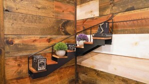 Eine Holztreppe mit minimalistischem Design, auf den Stufen eine Kamera und ein Blumentopf.
