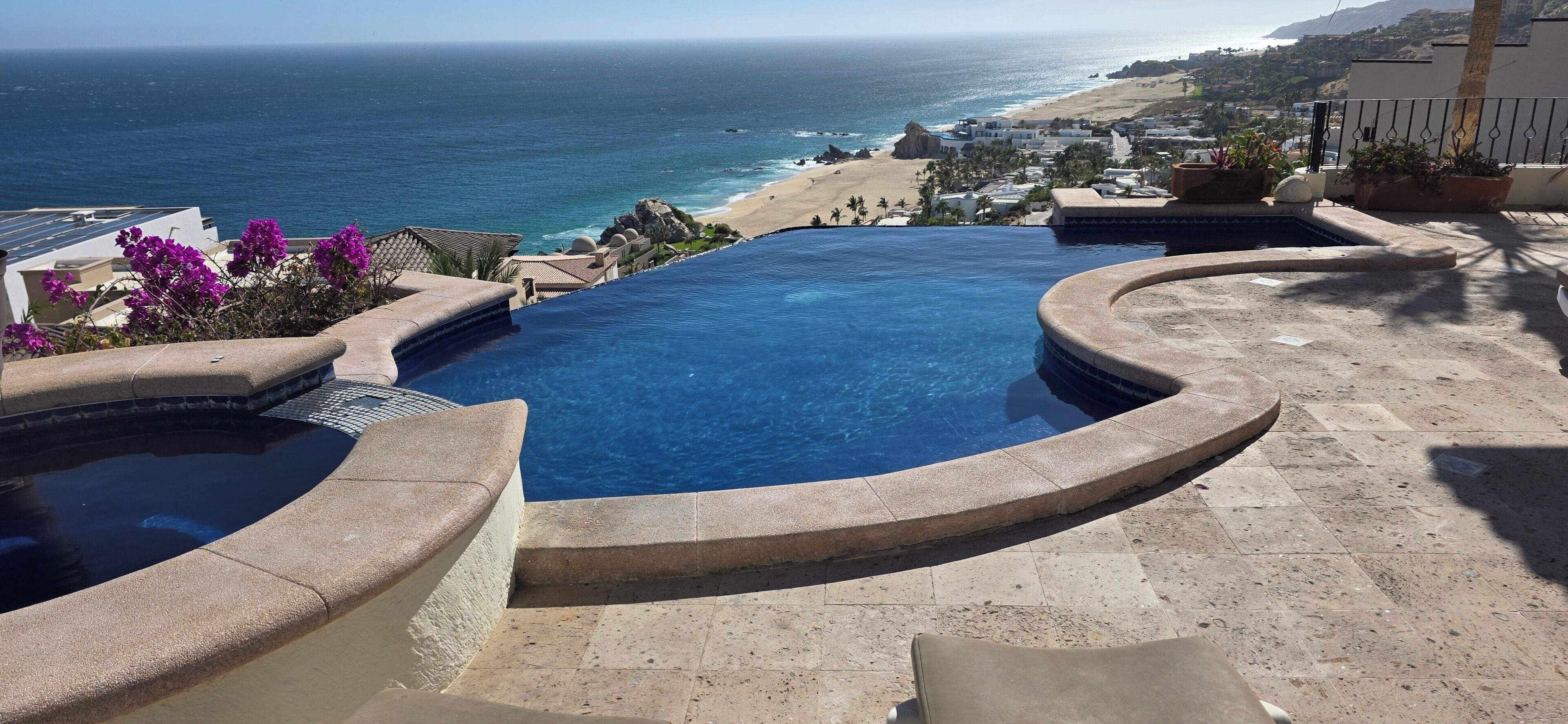 A infinity pool with a view of the ocean and beach.