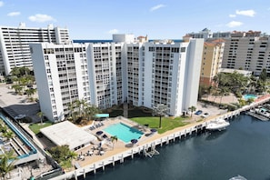 Ein Hochhaus mit Pool auf dem Dach, mehreren Balkonen und einem Yachthafen mit Booten.
