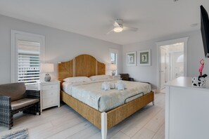 A bedroom with a bed, bedside tables, a chair, a ceiling fan, and a TV. - Shell Yeah! Waterfront House with Private Pool in Palm Acres (Fort Myers)