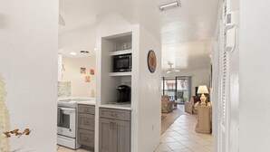 A kitchen with white cabinets, a microwave, and a stove. - Island Breeze Escape (Bradenton Beach)