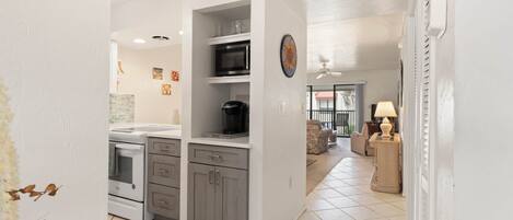 A kitchen with white cabinets, a microwave, and a stove.