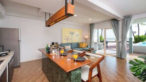 Una cucina moderna con angolo pranzo, divano e vista sull'oceano.