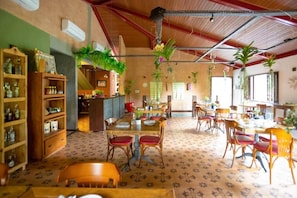A restaurant with wooden furniture, hanging plants, and a patterned floor.