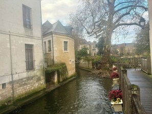 A narrow canal with buildings on one side and a wooden bridge. - Le Bovary - Charming studio on the château side (Vendôme)