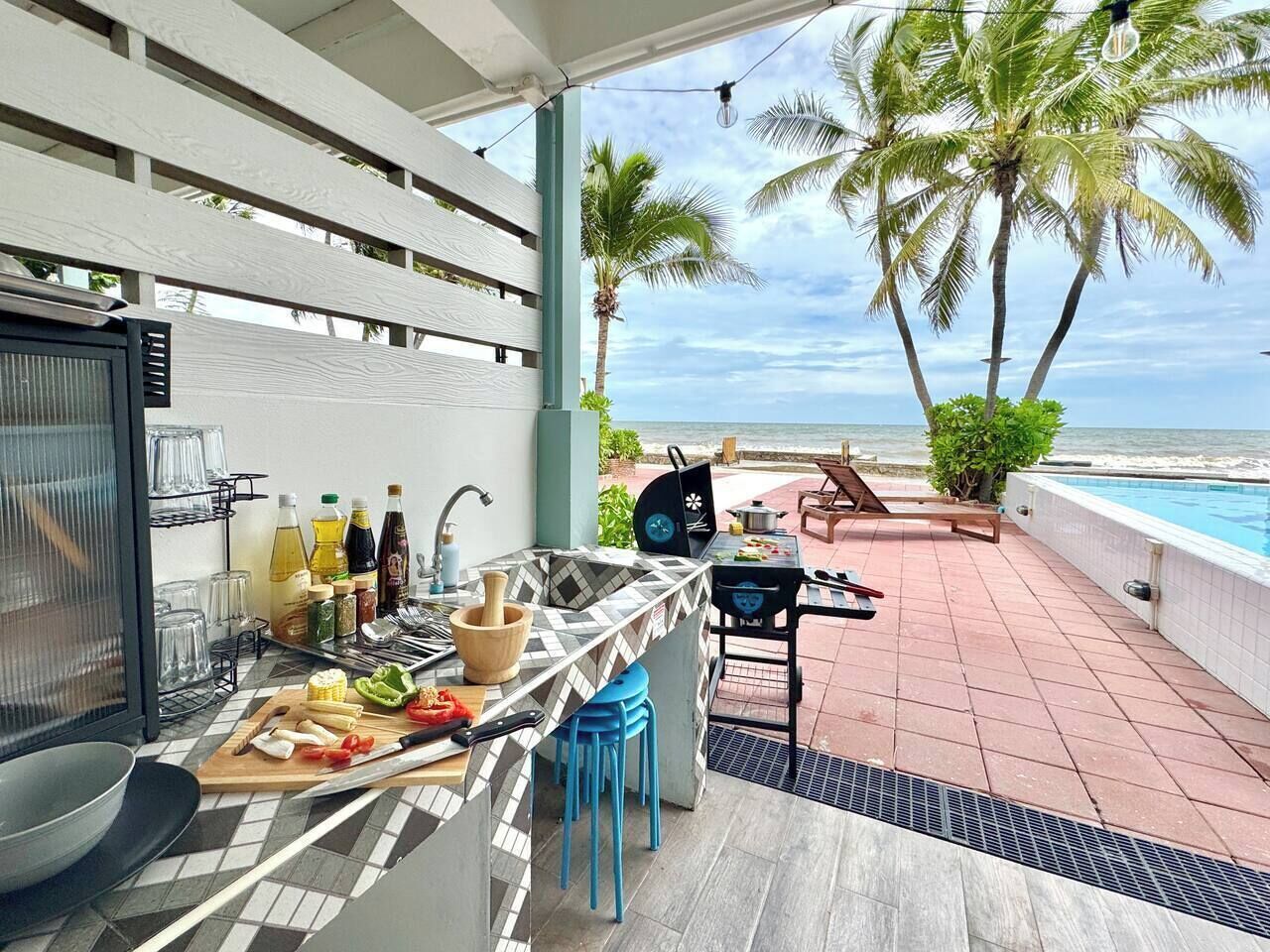 Una cucina con vista sull'oceano, una piscina e palme.