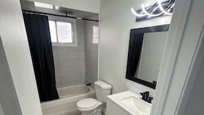 Un baño moderno con bañera, inodoro y lavabo.