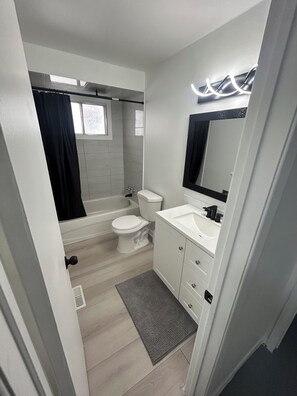 Une salle de bain moderne avec une baignoire, des toilettes et un lavabo.