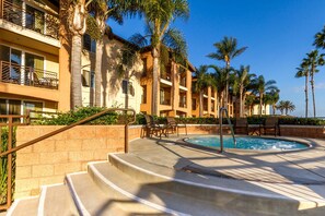 A hotel with a swimming pool, palm trees, and a staircase leading to the pool area. - Grand Pacific Palisades resort at Carlsbad California (Carlsbad)