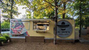 Un camión de comida llamado 'El Jefe's Authentic Taqueria' con un mural colorido y un logotipo circular.