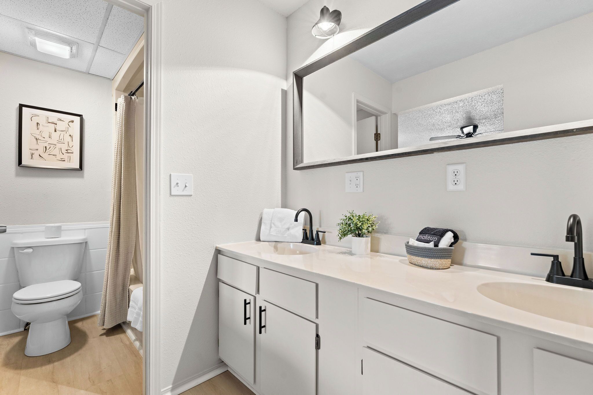 Un bagno moderno con toilette, lavabo e specchio.