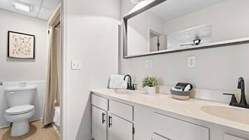 Un bagno moderno con toilette, lavabo e specchio.