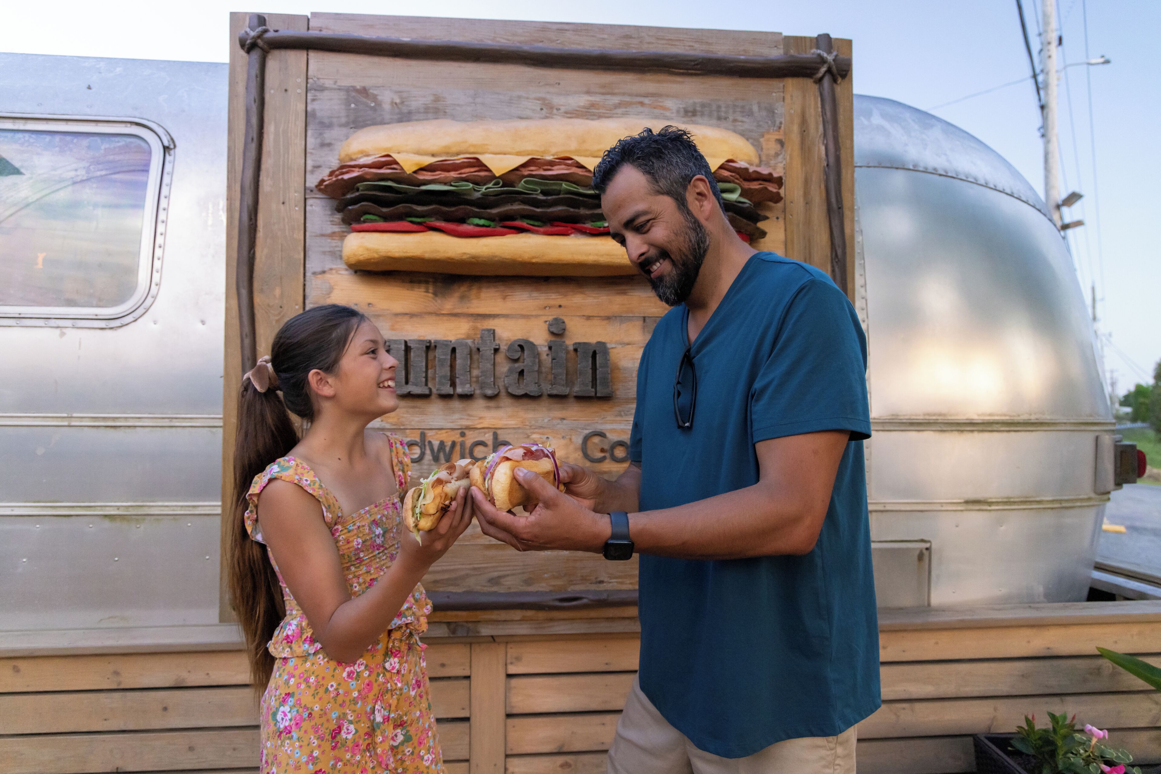 A wooden sign with a sandwich and the word 'Sandwich' on it.